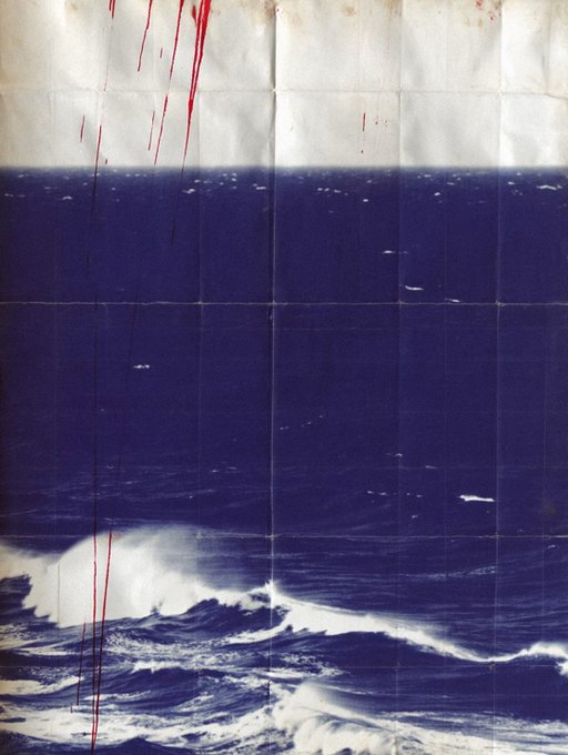 The image features a poster with a blue background that depicts an ocean scene, including waves crashing against the shoreline. The poster has been folded in half, creating a unique perspective of the ocean landscape. The text "gm folded horizons #2" is present on the poster, which could be related to the artist's name or a specific edition number. The post also mentions that this image was taken by @SuperRare, indicating that it might have been shared on social media platforms for artistic appreciation and discussion.