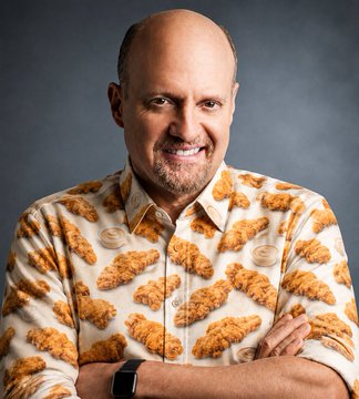 A smiling bald man poses with crossed arms while wearing a button-up shirt patterned with images of fried chicken.