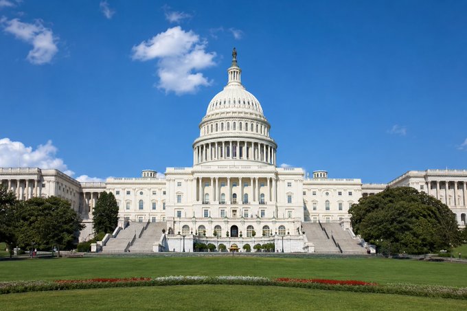 The United States Capitol building stands prominently against a blue sky, symbolizing the legislative action Senator Cynthia Lummis urges in the post to establish clear digital asset regulations before other nations set the rules for the U.S.