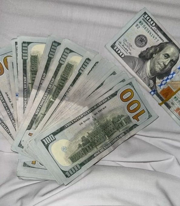 A fan of $100 bills featuring Benjamin Franklin is spread out on a white sheet, visually reinforcing the post's boast about "making money" this year.