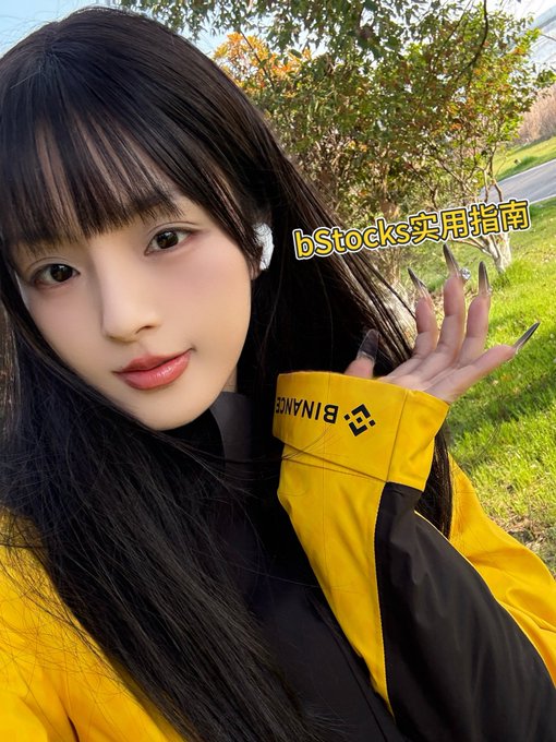 A woman in a yellow jacket with "BINANCE" text and logo poses outdoors, while the superimposed text reads "bStocks实用指南" (bStocks Practical Guide). The image relates to the post by highlighting Binance and suggesting content creation about bStocks for potential rewards.