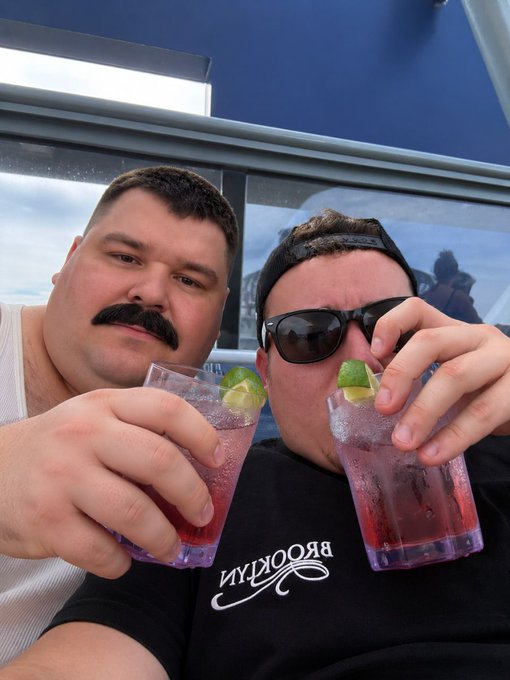 Two men clink pink cocktails garnished with lime wedges on a cruise ship deck, one wearing a black "BROOKLYN" cap and sunglasses, while the accompanying post jokes about Jack Duval's questionable trading practices with Stonkfun coins mid-vacation.