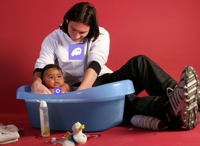 A man bathes a baby in a blue plastic tub against a red backdrop, with a rubber duck, baby bottle, and towel scattered nearby, while purple speech bubble icons (the Phantom and Discord/Monad logos) appear over the scene—relating to the post's promotion of MON token gas fees through the Phantom wallet with @monad and @phantom.