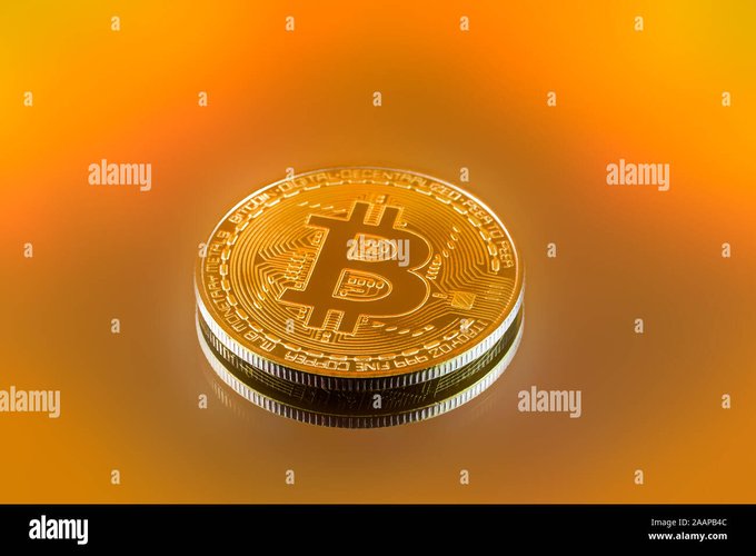 A 3D rendering of a gold-colored physical Bitcoin coin featuring the iconic '₿' symbol on its face, set against a warm orange gradient background.