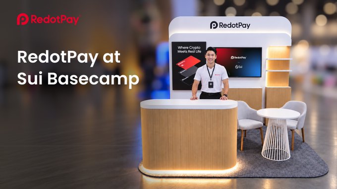 A promotional banner for 'RedotPay at Sui Basecamp' showing a person standing at a RedotPay branded booth with a display reading 'Where Crypto Meets Real Life'.
