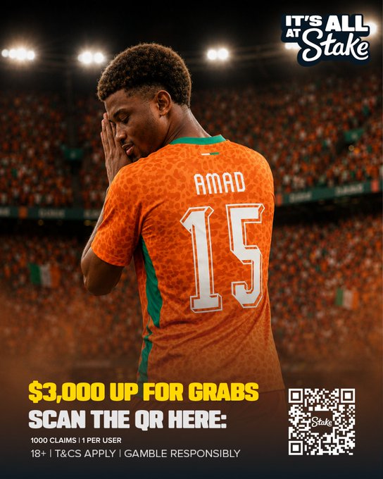 The image shows a dejected soccer player wearing an orange Ivory Coast jersey with "AMAD 15" on the back, his hand covering his face as he stands in a stadium filled with fans. The ad includes the text "IT'S ALL AT Stake," "$3,000 UP FOR GRABS," "SCAN THE QR HERE," and a QR code promoting a Stake.com gambling promotion. The image ties to the post by referencing the Ivory Coast's 1-0 halftime lead in a soccer match, using the player's disappointed expression to encourage users to bet on a goal being scored in the second half.