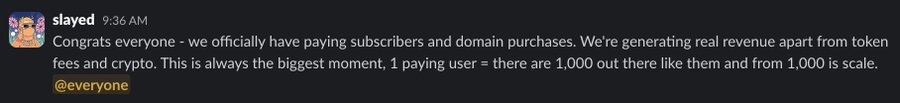 A Discord message from "slayed" at 9:36 AM announces to @everyone that the project now has paying subscribers and domain purchases, calling it "the biggest moment" and framing 1 paying user as a sign of 1,000 more potential customers and scalability. The image aligns with the accompanying post celebrating this milestone as a real revenue breakthrough beyond token fees and crypto.