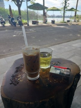 The image shows a table with two drinks and an ashtray or lit cigarette. There are also some motorcycles visible in the background. The context of this scene suggests that someone posted about Bitcoin, possibly indicating that they want people to participate in a "bitcoin challenge" where participants are encouraged to pull up the chart showing Bitcoin prices. This could be a fun way to encourage others to learn more about or get involved with cryptocurrency and digital assets.