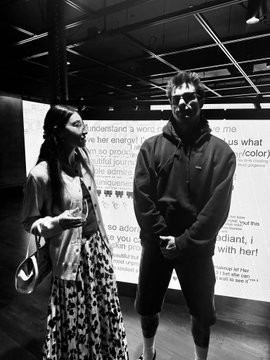 A black-and-white photo shows a woman in a patterned skirt and a bearded man in a hoodie standing in front of a "Node tn" event backdrop, with one visible name tag reading "Gretchen" alongside the other attendees. The image captures the speakers or presenters at the Node Tennessee conference referenced in the caption.