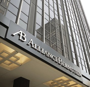 The image features a tall building with a white sign displaying "Alliance Bernstein", which reads the name of a financial company along with an estimate of $1 billion for its value. This estimate suggests that the building contains offices within the company, possibly indicating that this is a significant commercial or financial institution. The fact that it remains in service despite being described as "temporarily" failing to pay interest implies that the establishment might be still functional and operational, potentially providing essential services related to finance and investment.
