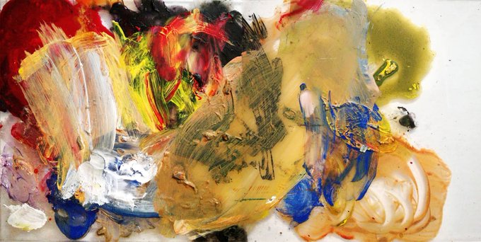 An abstract painting with thick, expressive brushstrokes in vibrant colors including red, yellow, green, blue, and white on a palette surface.