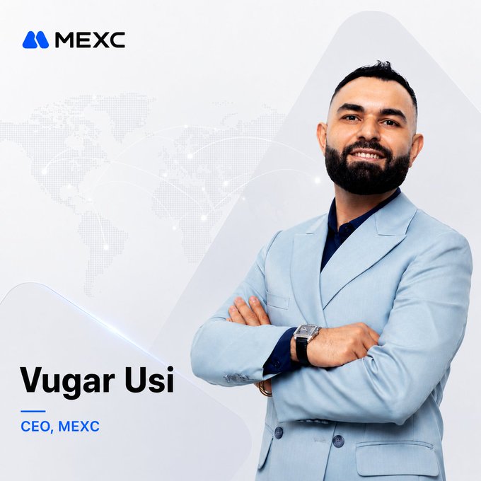 A professional headshot of Vugar Usi, CEO of MEXC, who is pictured smiling with arms crossed in a light blue blazer against a world map backdrop with the MEXC logo and his name and title displayed. The image accompanies a congratulatory message celebrating his first 100 days as CEO, referencing his public letter about MEXC's commitment to lowering barriers and expanding access for everyday investors.