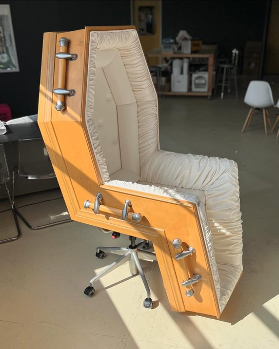 A creative upcycled chair made from a wooden door with the upholstered seating built into the door's panel, mounted on a standard office chair base.