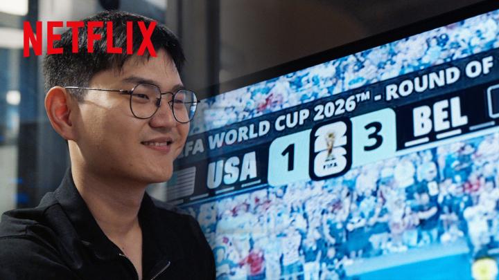 A man smiles in front of a TV displaying "FIFA WORLD CUP 2026™ - ROUND OF" with a score showing USA 1, BEL 3, beneath a Netflix watermark—visually tying the post to the newly released Netflix documentary about prediction markets like Polymarket, where such real-world sporting outcomes are wagered upon.