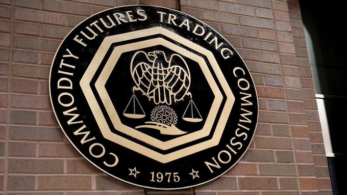 The image features a circular sign with a black border, mounted on a brick wall. The sign displays the text "CFTC Approves First U.S.-listed Bitcoin perpetual futures contract" and "Last week, the CFTC approved the first U.S.-listed bitcoin perpetual futures contract". Additionally, there is a quote from the CFTC about the future of cryptocurrency trading in the United States.
