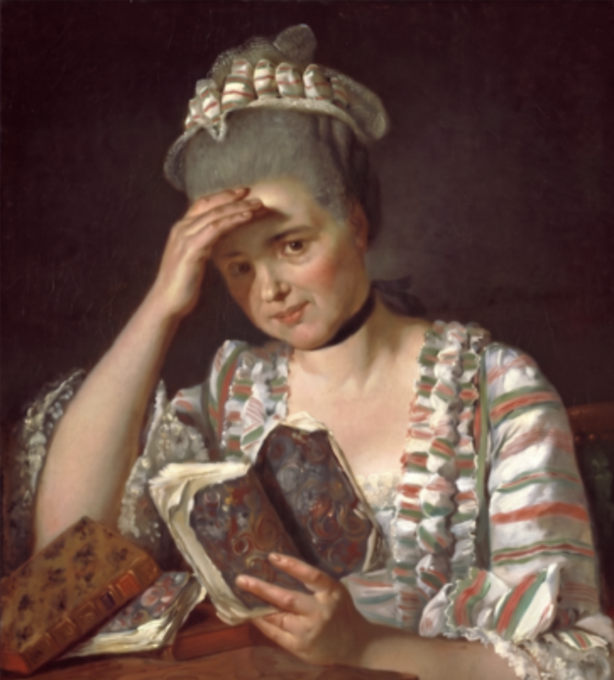 The image features a woman sitting at a table with her head resting on her hand, holding an open book in front of her face. She appears to be reading or studying something written on the pages. The background of the image is dark, which contrasts with the white and red striped dress she's wearing. There are also two books visible in the scene - one being held by the woman and another placed next to it. The presence of these books suggests that she might be engaged in a reading or studying session.