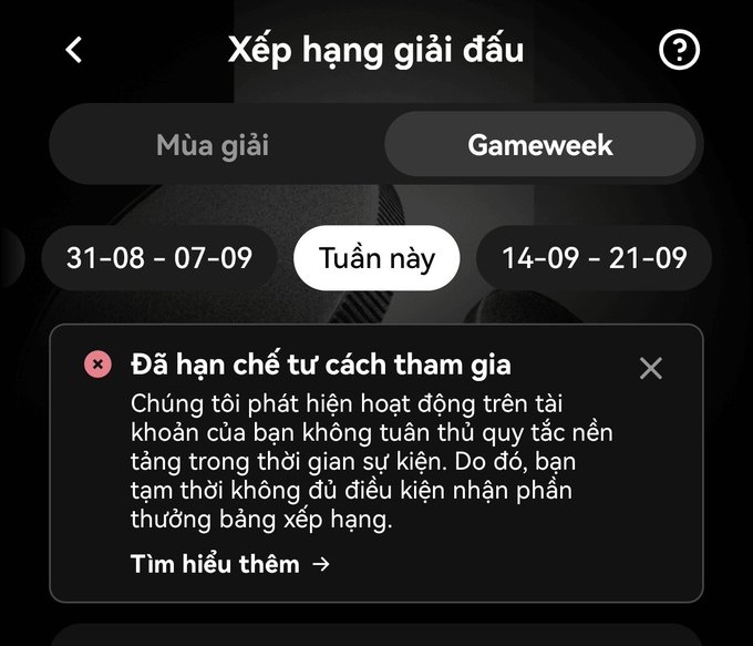A Vietnamese-language mobile app screen titled "Xếp hạng giải đấu" (Tournament Rankings) showing a notice that the user is restricted from participation due to suspicious account activity, with date options for Gameweek.