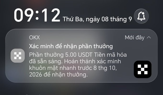 An iOS notification on a lock screen displays the time 09:12 and a message from OKX in Vietnamese, offering a 5.00 USDT cryptocurrency reward for completing face verification before October 8, 2026.