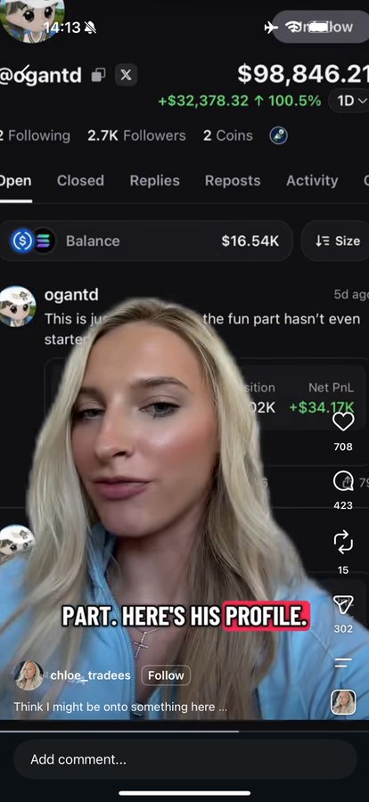 A blonde woman in a blue top speaks to the camera with a screenshot of an X profile behind her. The profile belongs to '@ogantd' and shows a portfolio value of $98,846.21 (+$32,378.32, 100.5%), with on-screen text reading 'PART. HERE'S HIS PROFILE.'
