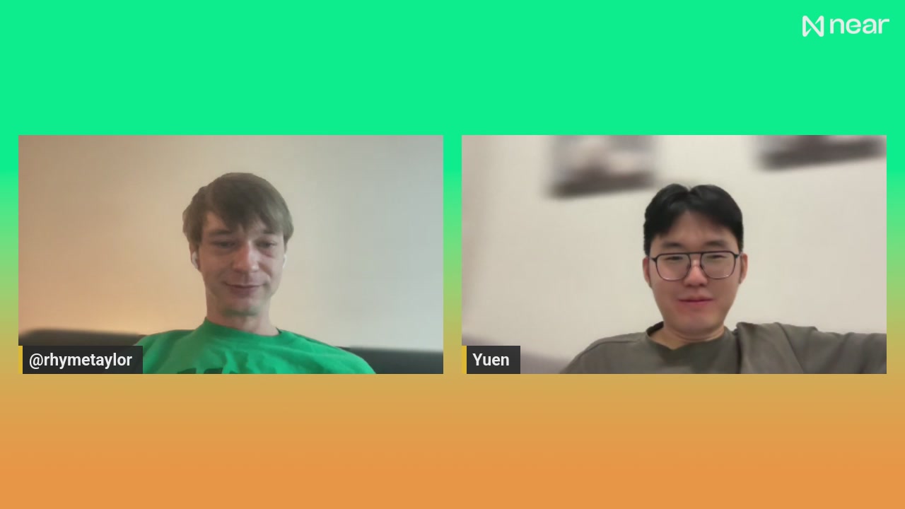 The image shows two men sitting next to each other, both looking at a computer screen with their faces displayed. They appear to be engaged in a video call or online meeting. The background of the image features an orange and green gradient color scheme, which is likely used for the background on the computer screen. The post that accompanies this image reads: "City Node #1 Launches Live from NEAR Malaysia". This suggests that the men are participating in a live event or discussion related to City Node's activities.