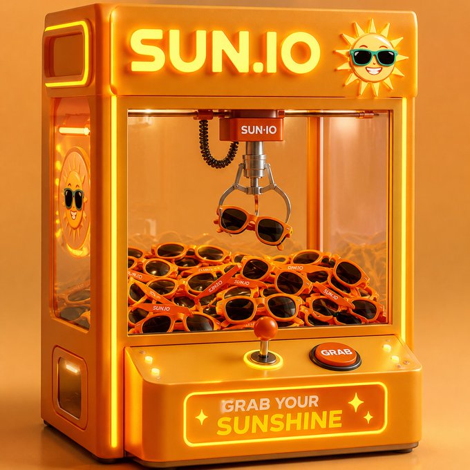 A vibrant orange arcade claw machine branded "SUN.IO" features a smiling sun mascot with sunglasses and is filled with orange sunglasses prizes, with a claw currently grabbing a pair. The machine's illuminated sign reads "GRAB YOUR SUNSHINE" alongside a "GRAB" button, playfully tying the DeFi platform's expanding features on TRON to a fun, easy-to-grab experience highlighted in the accompanying post about @justinsuntron and #TRONEcoStar.