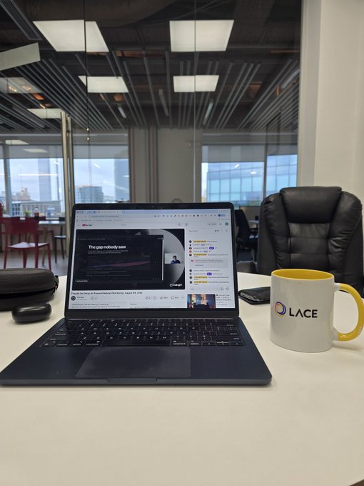 A workspace scene with an open laptop displaying a webpage titled 'The gap nobody saw', a white 'LACE' branded mug on the right, and a modern office with glass walls in the background.