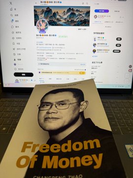 The image features a book titled "Freedoms of Money" by Changeng Thao, which has been signed by a person named @cz_binance. The book is placed next to an open laptop computer screen that displays a social media profile picture. The background of the image also includes text in Chinese and English, suggesting that this might be a post on a Chinese social media platform or website.