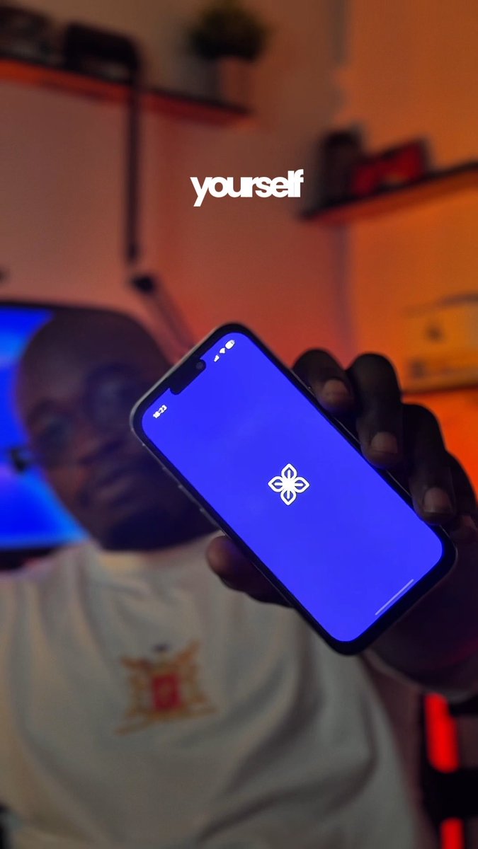 A person holding up a smartphone displaying a blue screen with a white logo, with the word "yourself" overlaid on the image.