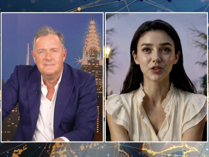 A split-screen broadcast showing a man in a blue blazer against a city skyline backdrop alongside a woman with long dark hair in a cream ruffled top.