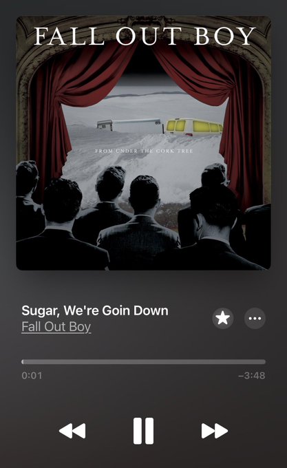 A Spotify music player screen displaying the song "Sugar, We're Goin Down" by Fall Out Boy from their album "From Under the Cork Tree," featuring artwork with an audience watching a yellow object on a stage behind red curtains.