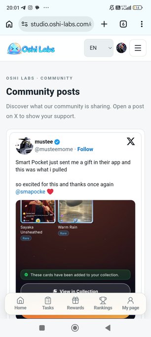 A mobile screenshot of the Oshilabs website showing a community post from @musteamome about receiving a gift in the Smart Pocket app, featuring cards labeled "Sayaka Unsheathed" and "Warm Rain."