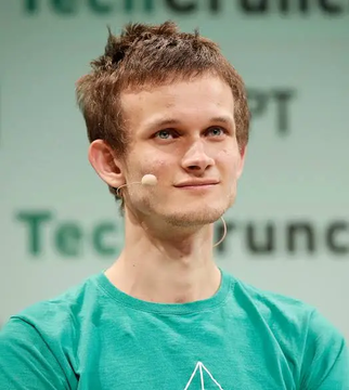 A young man with short brown hair wearing a green shirt and a headset microphone, photographed at what appears to be a TechCrunch event.