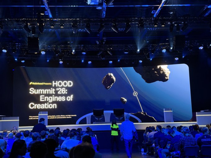 A packed conference hall awaits the upcoming talk at the Polygon **HOOD Summit '26: Engines of Creation**, with attendees gathering beneath a massive stage screen and dramatic asteroid-themed visuals. The image sets the scene for Vlad's imminent presentation, capturing the crowd's anticipation before his talk begins.