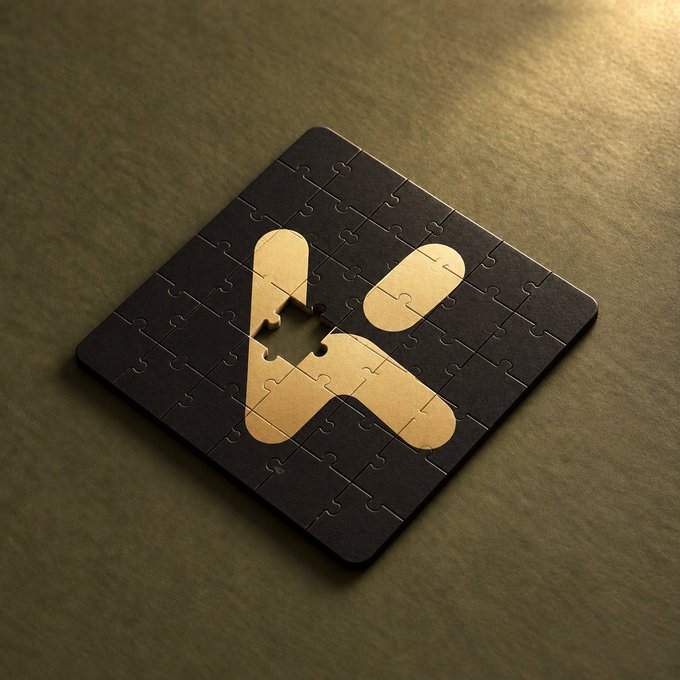 A dark-colored jigsaw puzzle featuring a beige stylized 'H' logo resting on a textured olive-green surface.