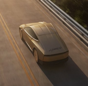 A sleek silver concept car driving on a multi-lane highway, with 'CYBERTRUCK' written on its rear side.