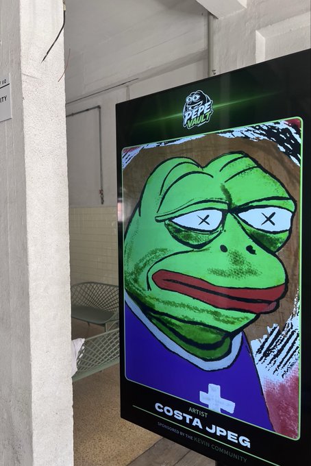 The image features a poster of a frog with crossed eyes that says "Costa J peg" at the bottom. The poster also has a message about the importance of the real pegasus species being remembered, which seems to be related to the Pepe series.