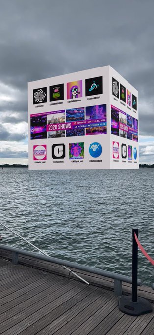 A large floating cube billboard displays various event logos and '2026 SHOWS' images on the water near a wooden pier.