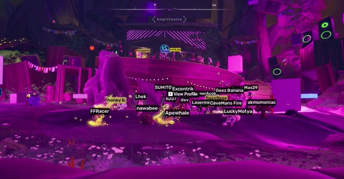 A purple-lit 3D virtual game environment shows multiple player avatars gathered in an amphitheater with names like 'SUMITO Excentrik', 'Geez Banana', 'Max29', 'Apewhale', 'LuckyMotya', and 'akmomoniac' visible above their heads.