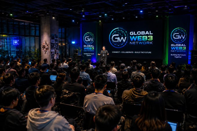 A large audience attends a 'GLOBAL WEB3 NETWORK' conference, with a speaker presenting on stage in front of a screen reading 'CONNECT • COLLABORATE • BUILD THE FUTURE'.