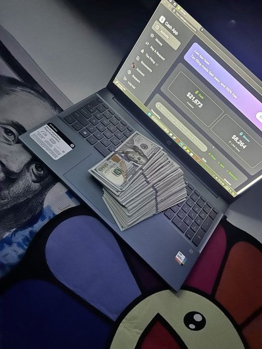 A laptop displaying a Cash App screen showing a balance of $3,853, with stacks of cash, an iPhone, and a driver's license placed on the keyboard.