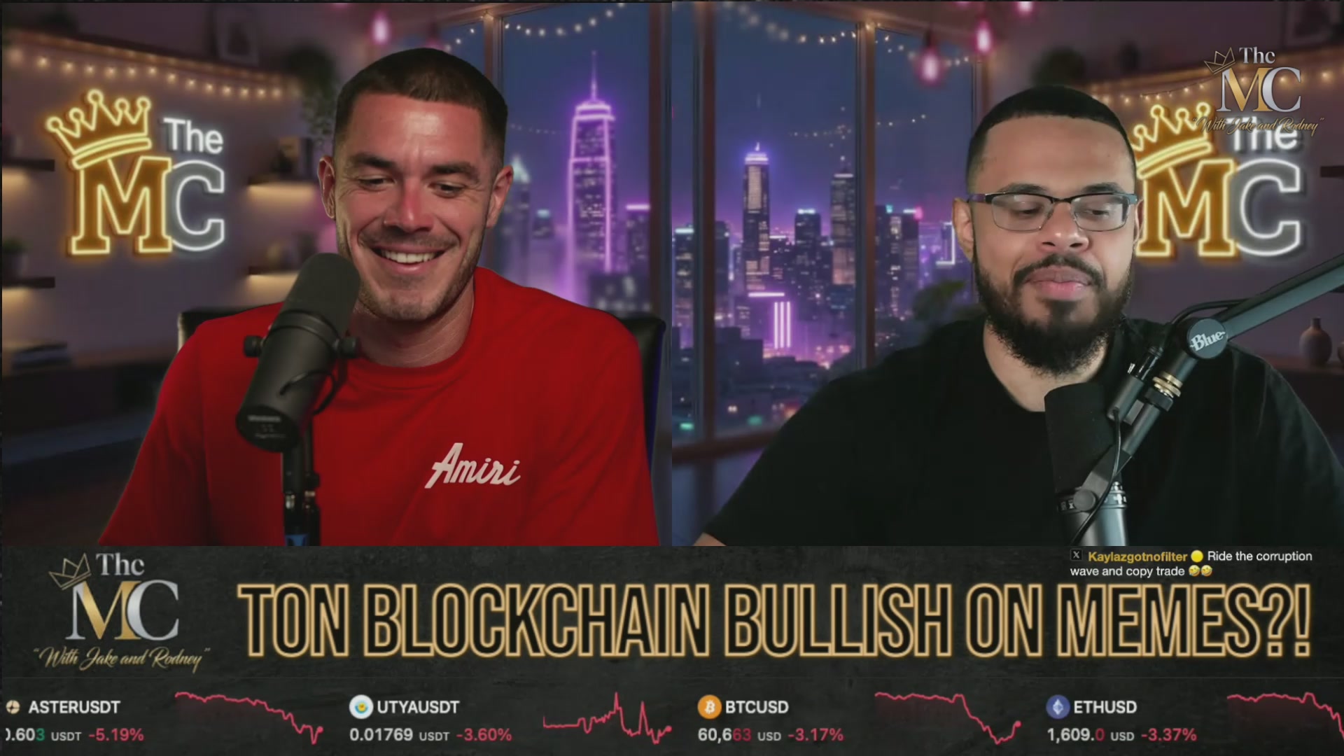 The image features two men sitting behind microphones, likely participating in a podcast or radio show. They are both wearing red shirts, which adds a pop of color to their appearance. The background shows a city skyline at night with buildings illuminated by lights, creating an urban atmosphere for the discussion. The focus of the image is on the conversation between the two men and not directly related to the post about memes.