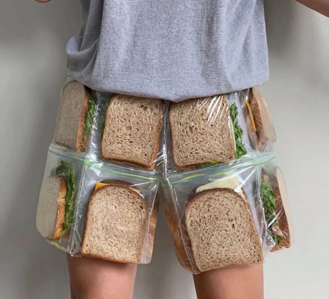 A surreal photo of a person wearing shorts made of clear plastic bags stuffed with sandwich-making ingredients like bread, cheese, lettuce, and meat.