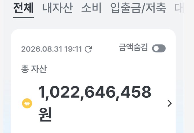 A Korean banking app screenshot showing total assets of 1,022,646,458원 (approximately 1.02 billion KRW) in "총 자산" (total assets) as of 2026.08.31 19:11, with "금액숨김" (hide amount) toggle off and the ₩ currency symbol displayed, illustrating the user's stated net worth milestone.