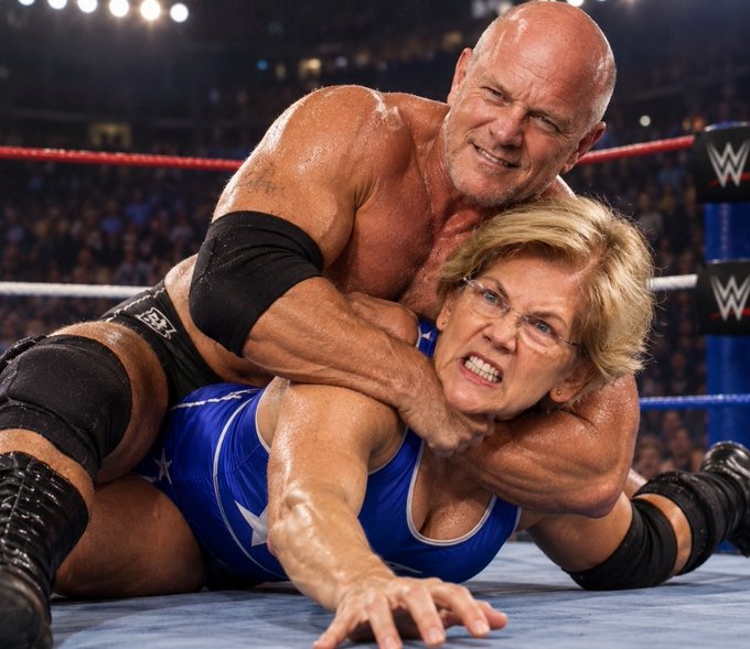 A WWE wrestling match photo showing wrestler Goldberg applying a headlock submission hold on Senator Elizabeth Warren, who is wearing a blue wrestling singlet with white stars inside a wrestling ring.