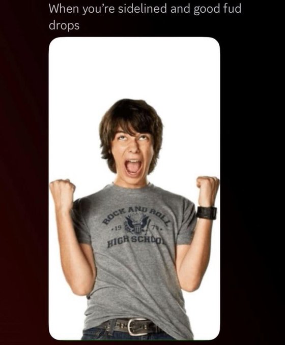 The image shows a young man with dark hair wearing a gray "Rock and Roll High School" t-shirt, cheering excitedly with both fists raised and mouth open in a jubilant expression. The caption at the top reads: "When you're sidelined and good fud drops."