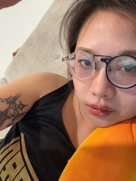 A selfie featuring a person with round glasses and a visible arm tattoo, with the accompanying post highlighting their digital artwork titled "The SPINE-BIRTH" being listed on SuperRare with a reserve price of 0.35 ETH.