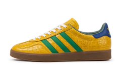 A single yellow Adidas sneaker with green stripes and a blue heel tab, displayed against a white background.