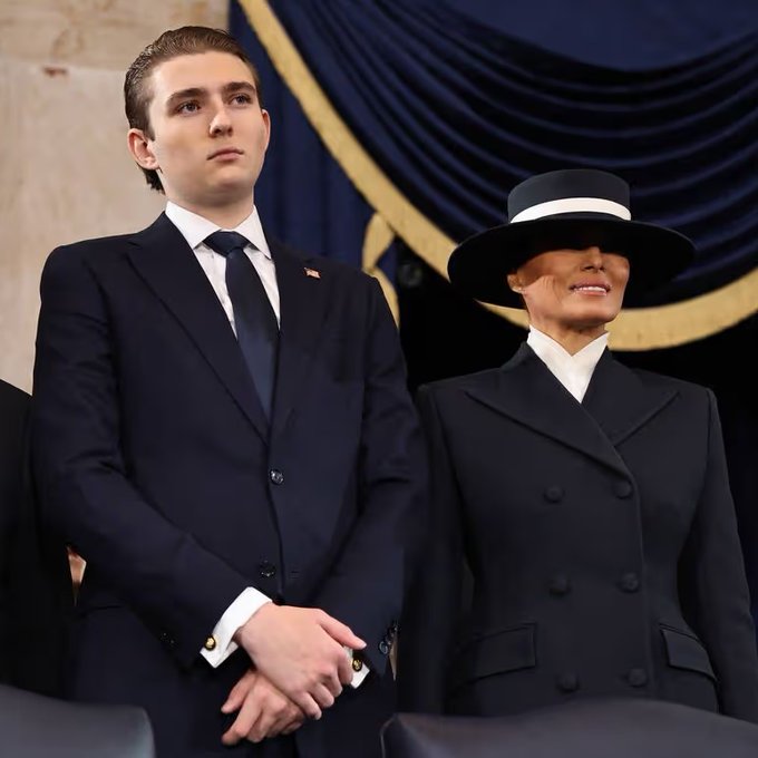 Barron Trump stands beside his mother Melania Trump, both dressed in formal black attire, at what appears to be an official event. The image accompanies a report claiming Barron's estimated $150 million net worth exceeds his mother's, primarily derived from the family's World Liberty Financial crypto venture.