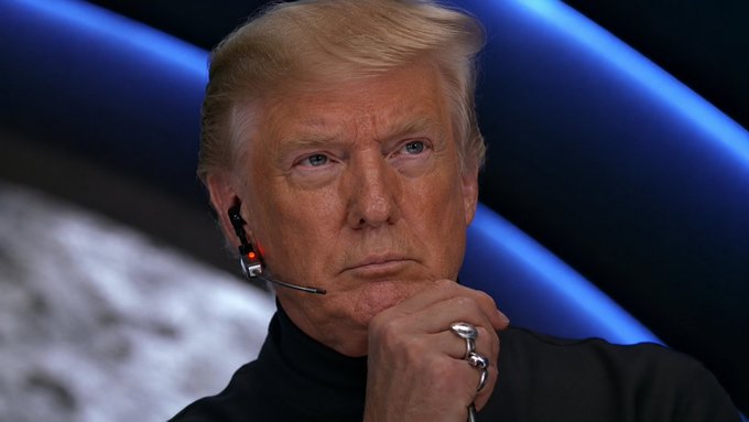 A man resembling Donald Trump, wearing a headset and rings, looks pensive against a blue and grey background, relating to the post's call for a $40,000 target.