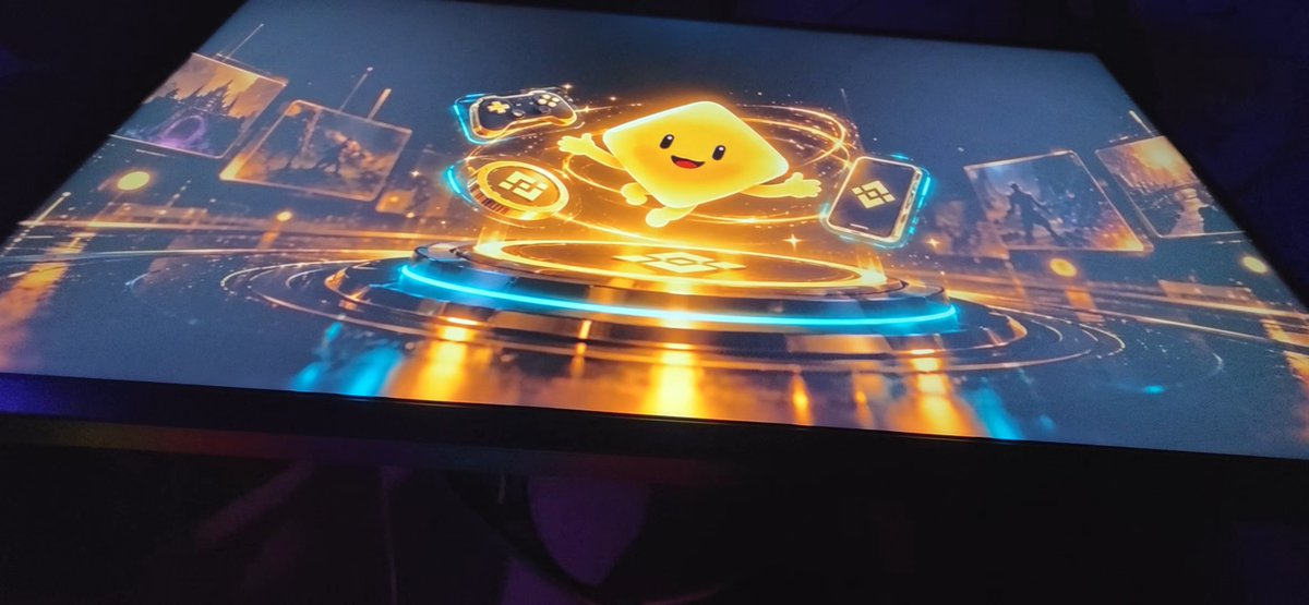 A digital display or table top showing a glowing yellow cartoon character surrounded by game controller icons and floating screen displays in a futuristic, neon-lit design.
